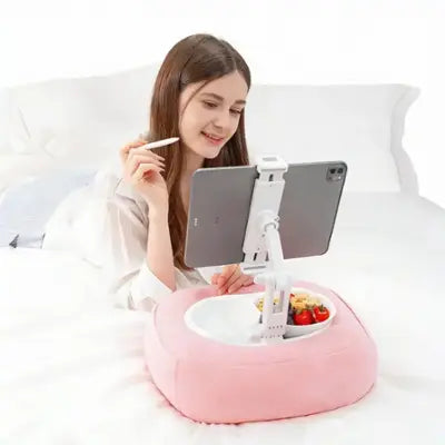 Pink pillow tablet stand in use with tablet and snack bowl